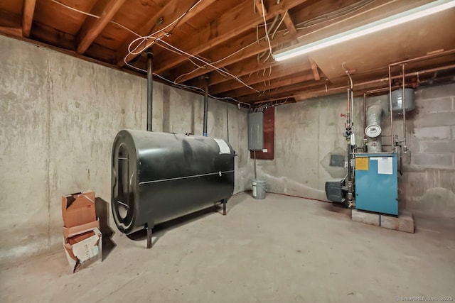 unfinished basement with a heating unit, electric panel, and heating fuel