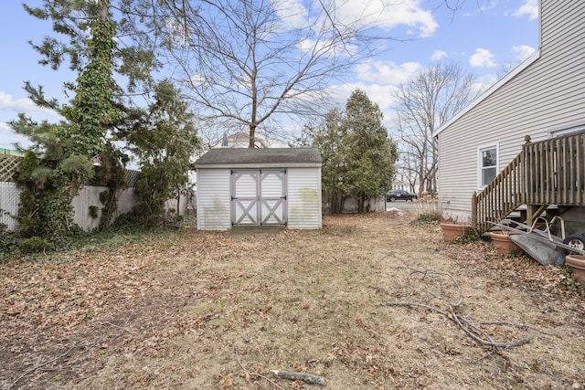 view of yard featuring fence, a storage unit, and an outdoor structure