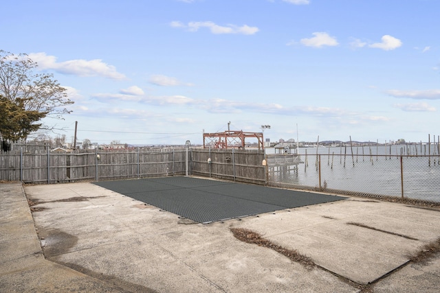 view of swimming pool featuring a boat dock and fence