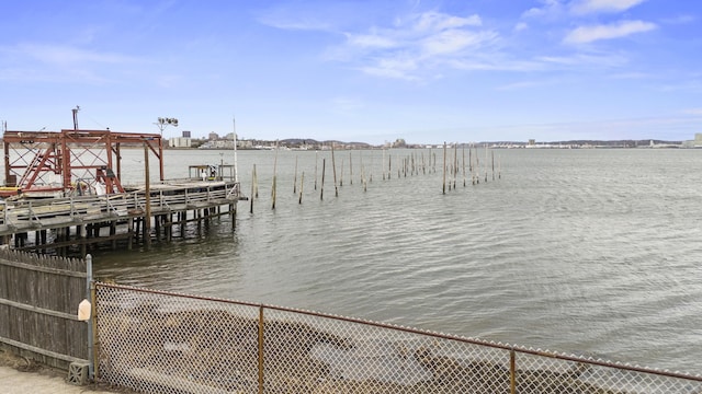 view of dock featuring a water view and fence