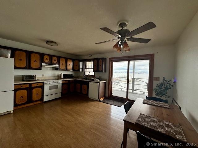 kitchen featuring white appliances, ceiling fan, under cabinet range hood, and dark wood-type flooring