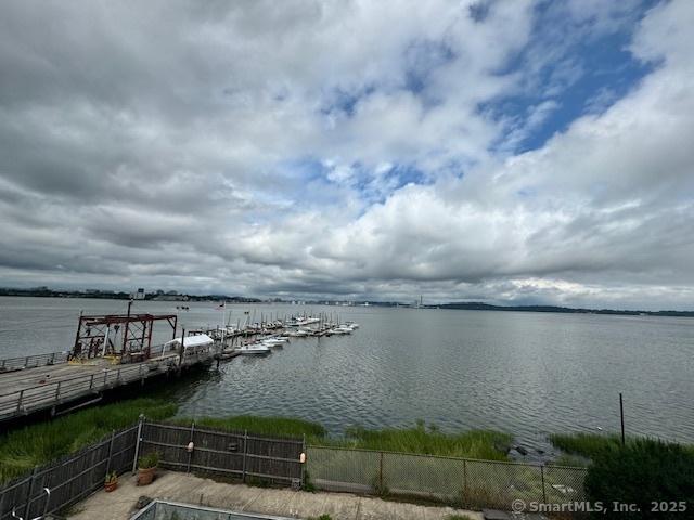 dock area with a water view and fence