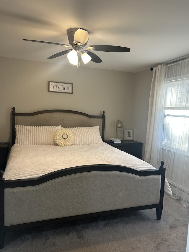 bedroom with a ceiling fan, baseboard heating, and carpet flooring