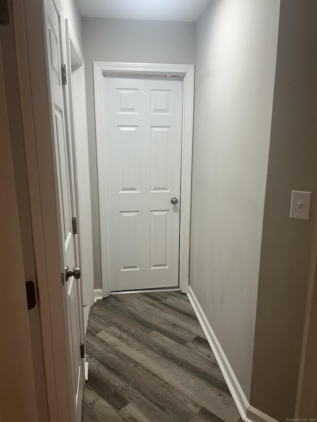 hallway with dark wood-style floors and baseboards