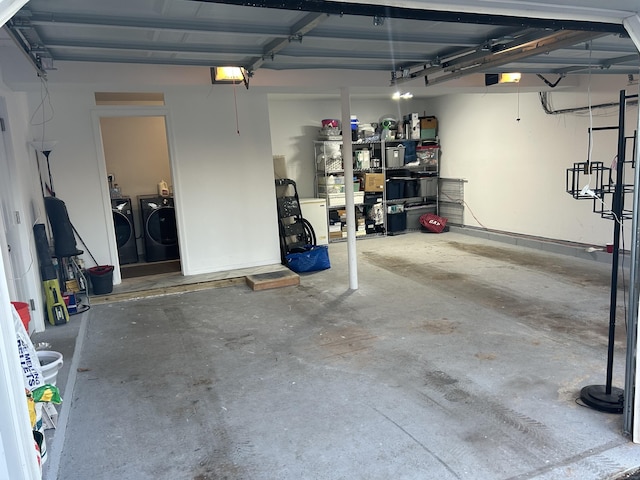 garage with a garage door opener and washing machine and dryer