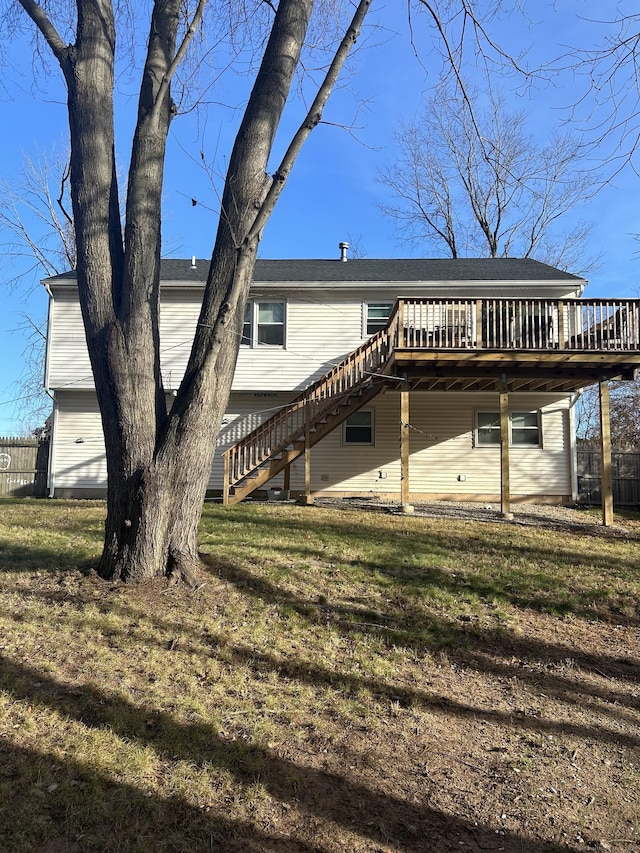 rear view of property featuring a yard, stairs, fence, and a wooden deck