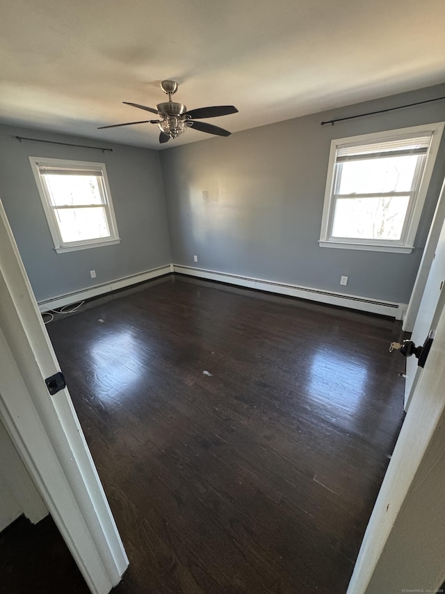 empty room with a baseboard heating unit, ceiling fan, wood finished floors, and baseboards