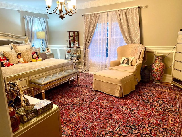 sitting room featuring carpet, a wainscoted wall, crown molding, a decorative wall, and an inviting chandelier