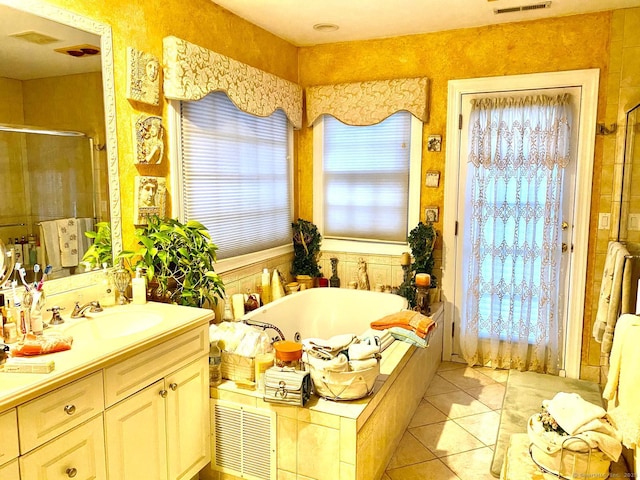 bathroom with a stall shower, a garden tub, vanity, and tile patterned floors