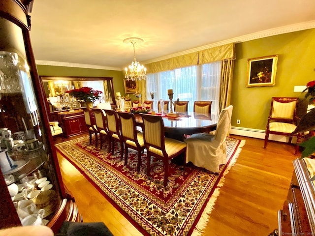 dining room featuring wood finished floors, crown molding, baseboards, and an inviting chandelier