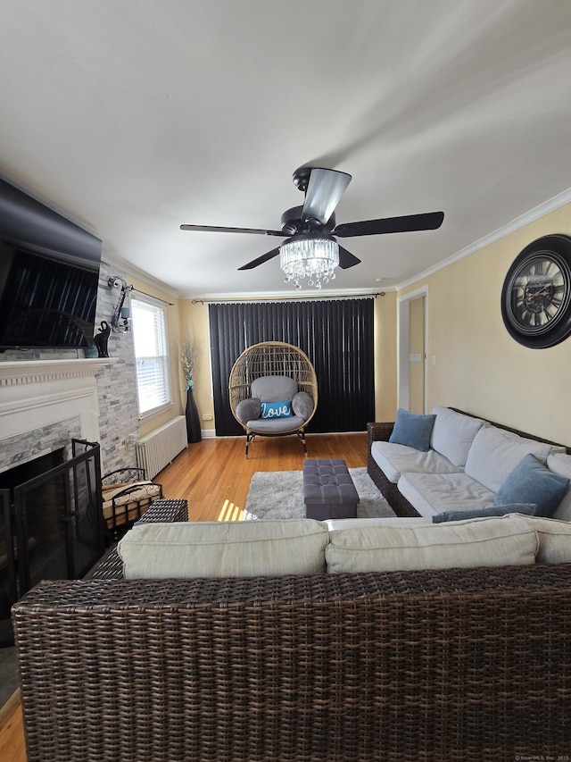 living area featuring ornamental molding, wood finished floors, a high end fireplace, and radiator