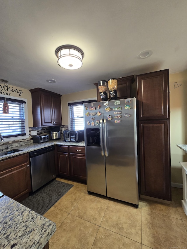 kitchen featuring a healthy amount of sunlight, appliances with stainless steel finishes, a sink, and light tile patterned flooring