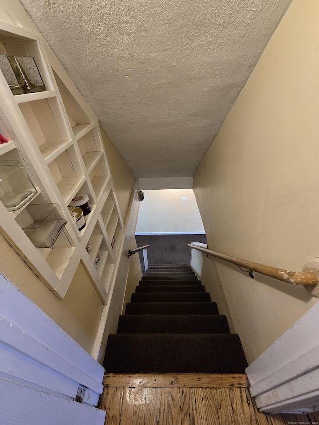 stairway with a textured ceiling