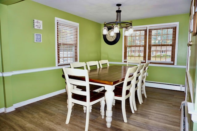 dining space with an inviting chandelier, baseboards, a baseboard heating unit, and wood finished floors