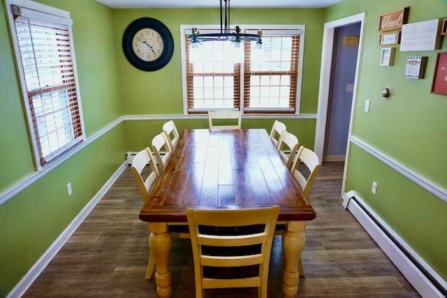 unfurnished dining area featuring a healthy amount of sunlight, baseboards, baseboard heating, and wood finished floors