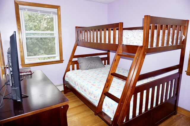 bedroom featuring a baseboard radiator and wood finished floors