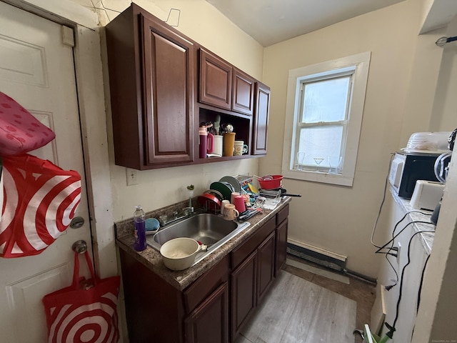 kitchen with washer and dryer, a sink, dark countertops, and white microwave