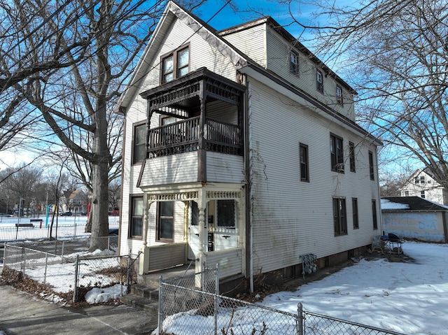 view of front of home featuring a balcony and a fenced front yard