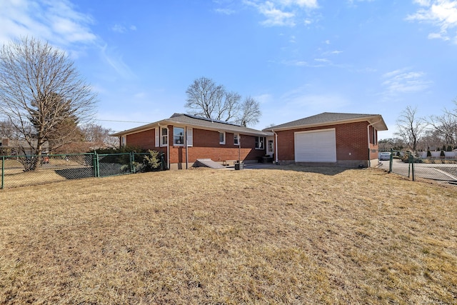 view of front facade with brick siding, fence, a front yard, an attached garage, and a gate