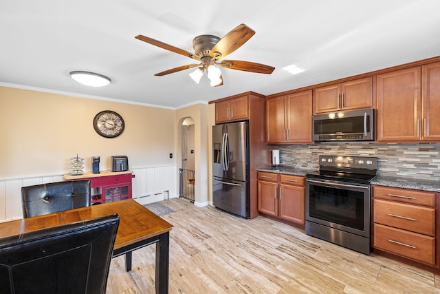 kitchen featuring stainless steel appliances, brown cabinetry, a baseboard heating unit, and ornamental molding