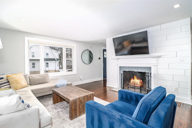 living area featuring recessed lighting, a fireplace, wood finished floors, and baseboards