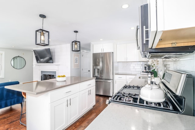 kitchen featuring appliances with stainless steel finishes, white cabinetry, dark wood finished floors, and tasteful backsplash