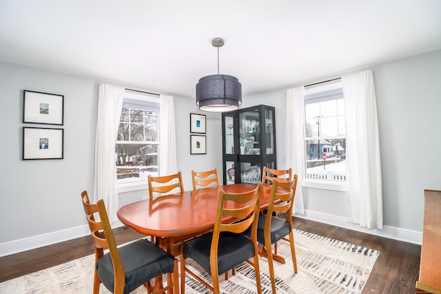 dining space featuring wood finished floors and baseboards