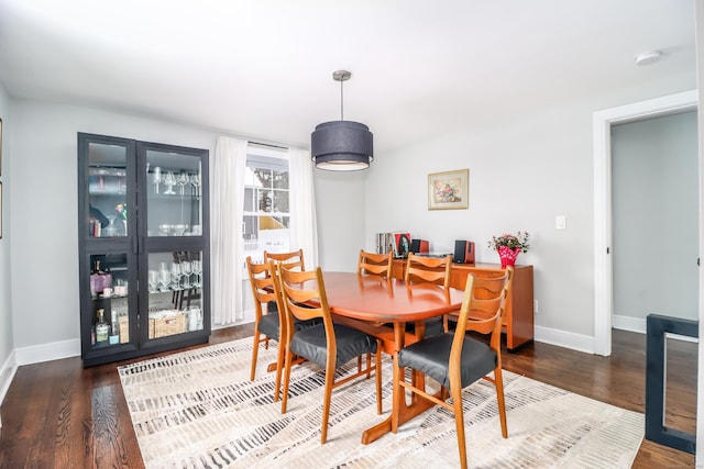 dining space featuring baseboards and wood finished floors