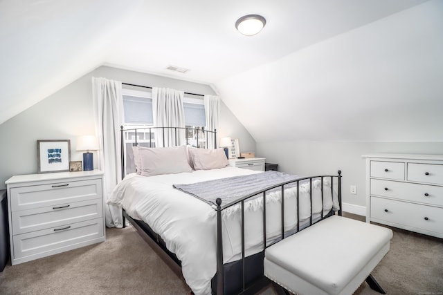 carpeted bedroom featuring visible vents and vaulted ceiling