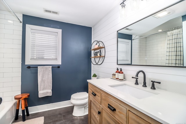 full bathroom with toilet, baseboards, visible vents, and vanity