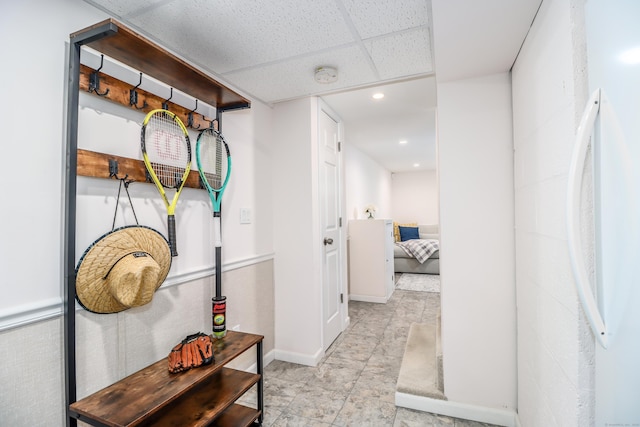 corridor featuring a paneled ceiling, baseboards, and recessed lighting