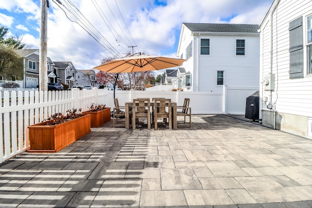 view of patio / terrace featuring a fenced backyard, a residential view, area for grilling, and outdoor dining space