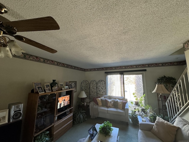 living room featuring a ceiling fan, stairway, and a textured ceiling