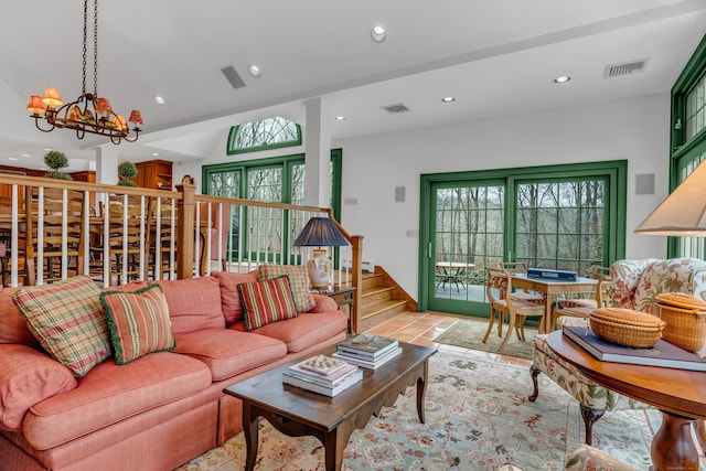 living room featuring visible vents, a wealth of natural light, and a chandelier