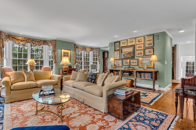 living area with baseboard heating, recessed lighting, wood-type flooring, and ornamental molding