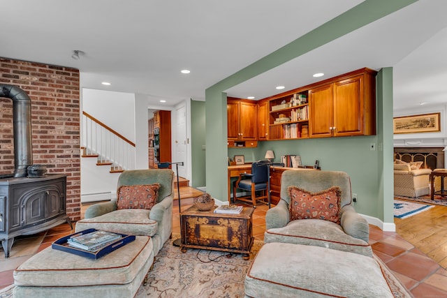 living area featuring baseboards, a baseboard radiator, built in study area, a wood stove, and recessed lighting