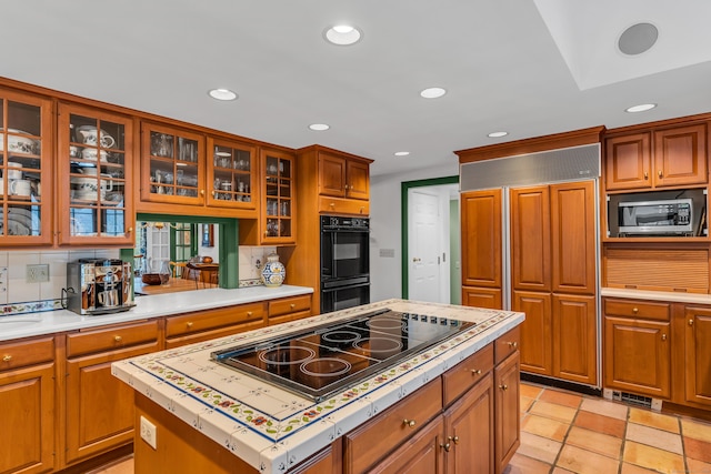 kitchen featuring recessed lighting, backsplash, black appliances, and light countertops