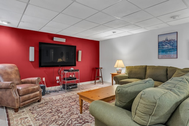 living area with baseboards and a paneled ceiling