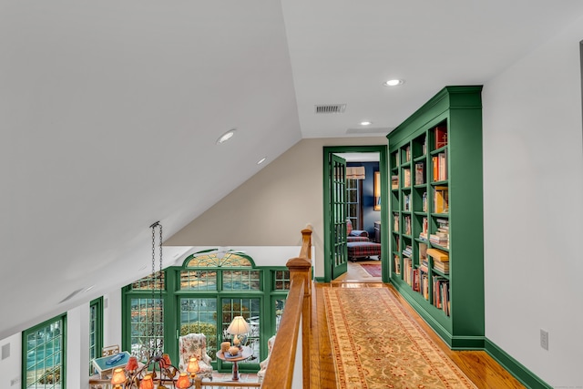 hallway with visible vents, light wood-style flooring, recessed lighting, baseboards, and vaulted ceiling