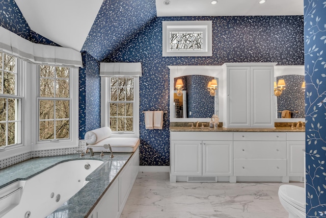604 W Lake Ave, Guilford, CT 06437 - bathroom featuring a tub with jets, marble look tiles, vaulted ceiling, vanity, and recessed lighting