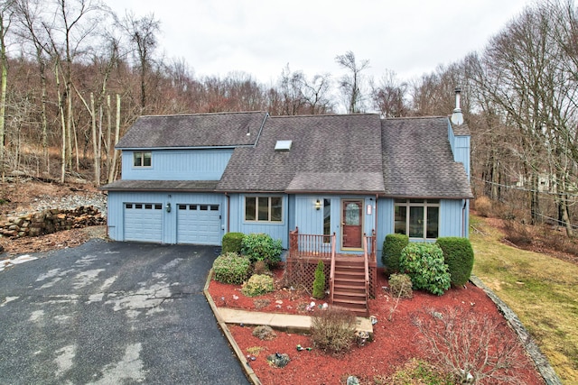 view of front of property featuring driveway, roof with shingles, and an attached garage