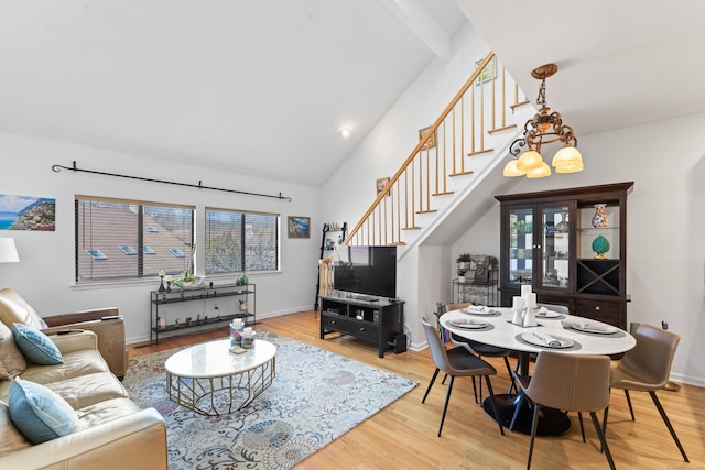 living room featuring baseboards, stairway, and wood finished floors