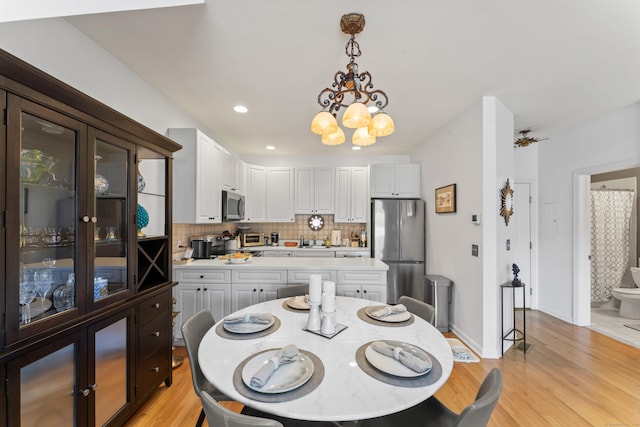 dining room featuring a chandelier, recessed lighting, light wood-style flooring, and baseboards