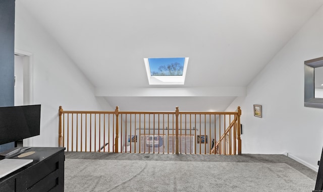 interior space featuring lofted ceiling with skylight and carpet flooring