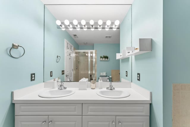 full bath featuring a stall shower, visible vents, a sink, and double vanity