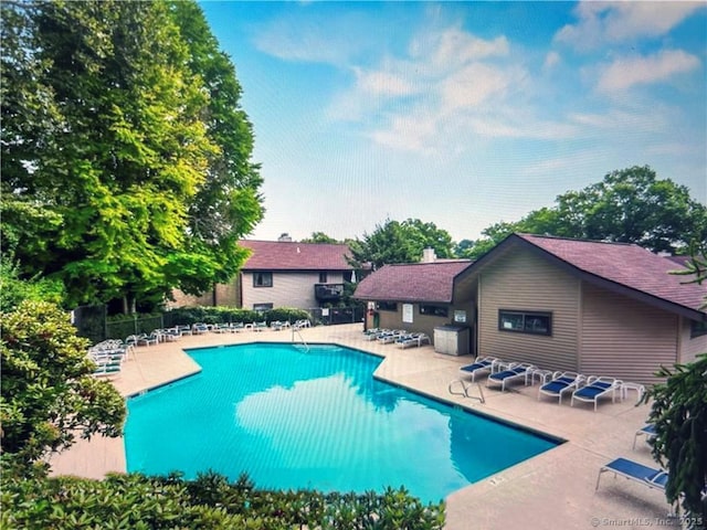 community pool with a patio area and fence