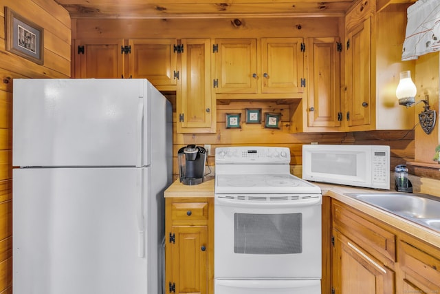 kitchen featuring white appliances, wood walls, and light countertops