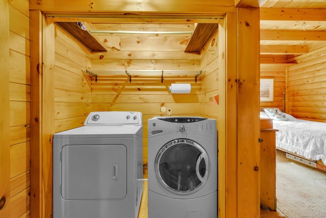 laundry room featuring carpet floors, laundry area, wood ceiling, wood walls, and washing machine and dryer