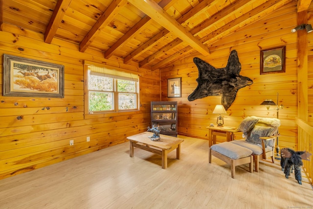 living area with wood finished floors, wooden walls, vaulted ceiling with beams, and wood ceiling