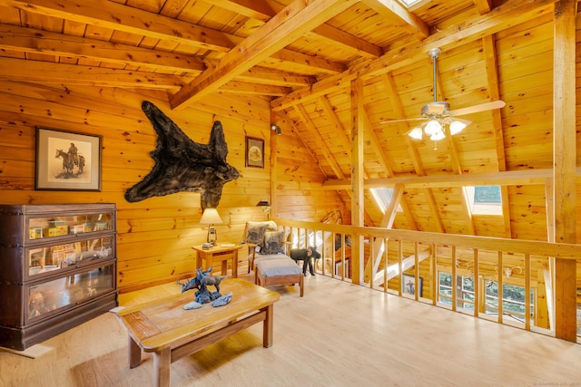 sitting room featuring lofted ceiling with skylight, wooden walls, wooden ceiling, and wood finished floors